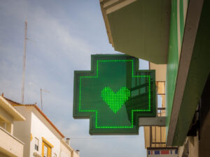cartel led verde para farmacia con un corazón